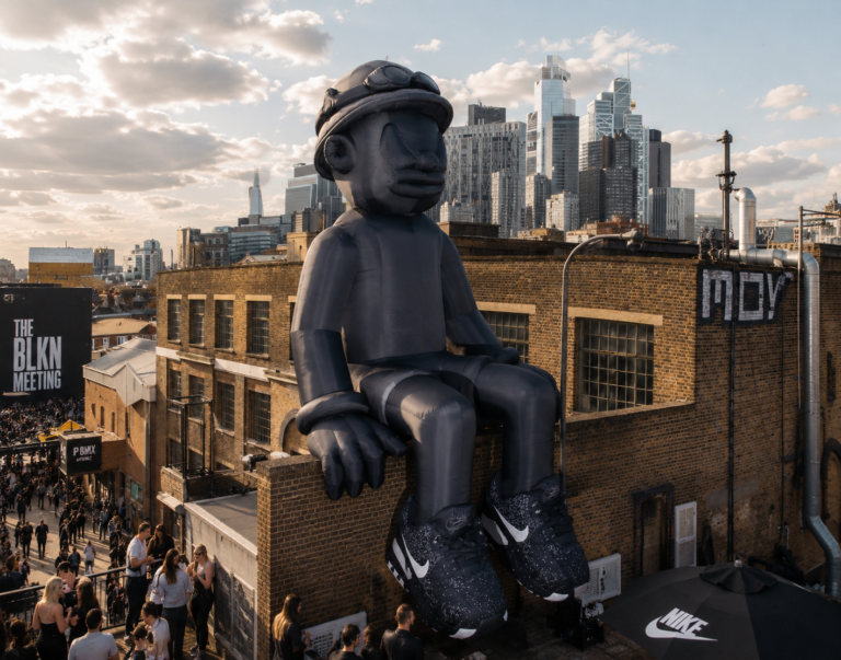 Giant inflatable urban character seated on a rooftop during a city event