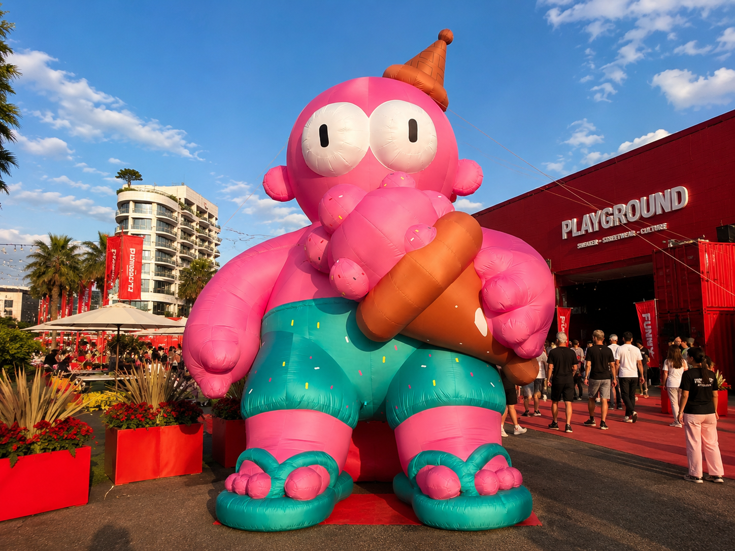 Giant pink inflatable character holding an ice cream at an outdoor lifestyle event