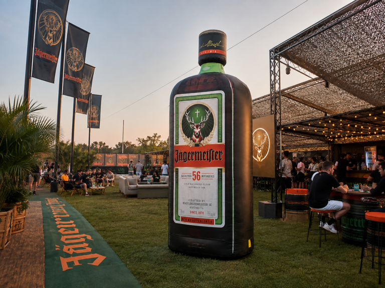 Giant inflatable beverage bottle displayed at an outdoor branded event