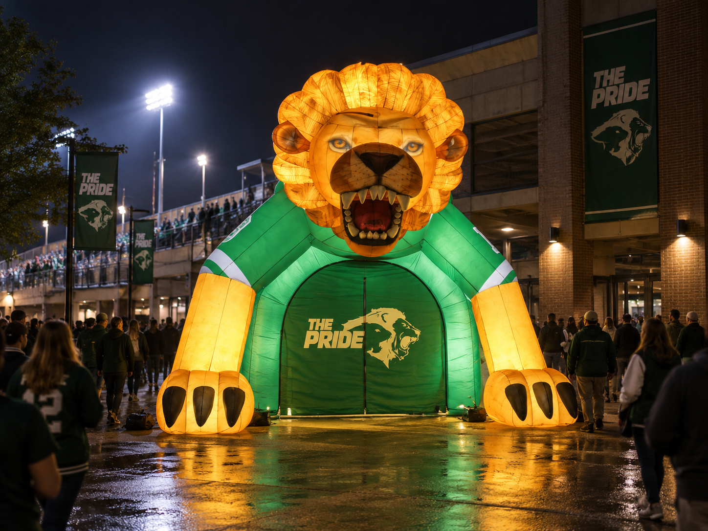 Illuminated giant inflatable lion entrance tunnel displayed at a nighttime sports event